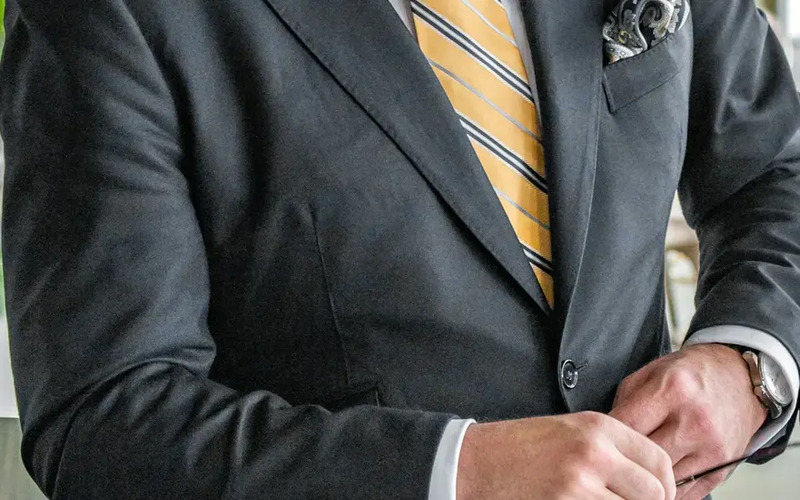 A close up of a man in a stylish gray Pearce Bespoke custom suit.