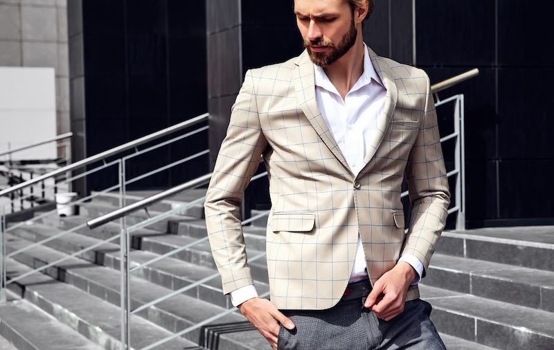 A man in a custom blazer with a blue grid on it - learn more about custom blazers with Pearce Bespoke 