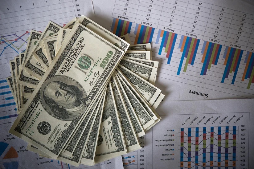 A stack of money on analytic sheets - The Power of Franchise Support in Achieving Success with Pearce Bespoke 