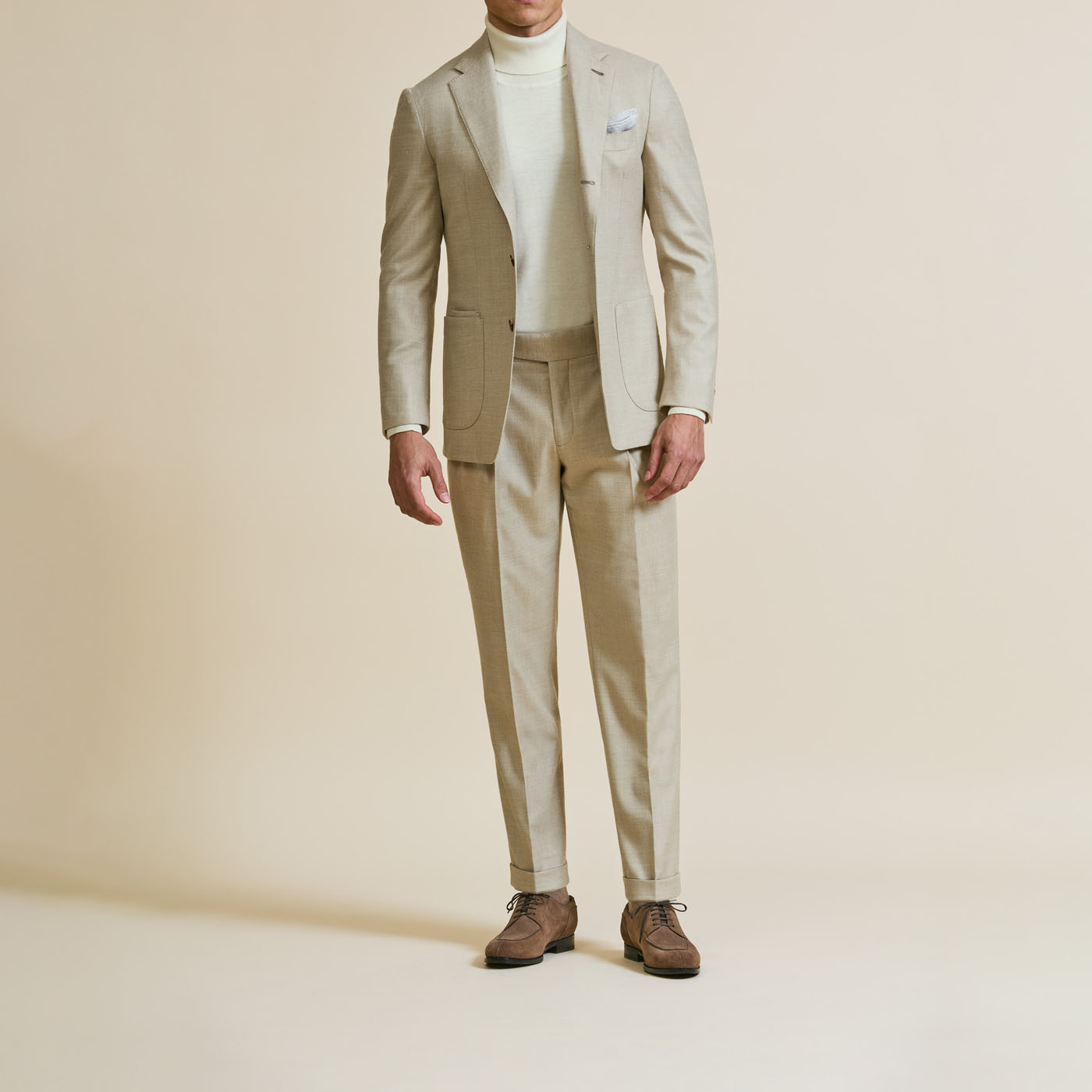 A person wearing a stylish cream Pearce Bespoke Greater Syracuse suit.