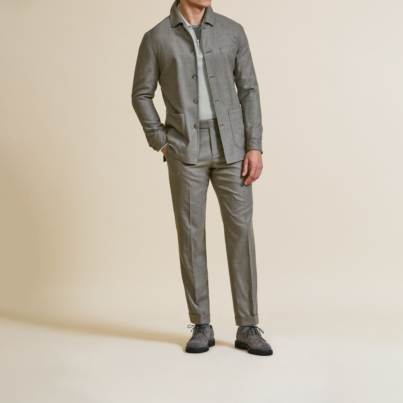 A model wearing a gray Pearce Bespoke Greater Syracuse custom suit, casually open without a tie.