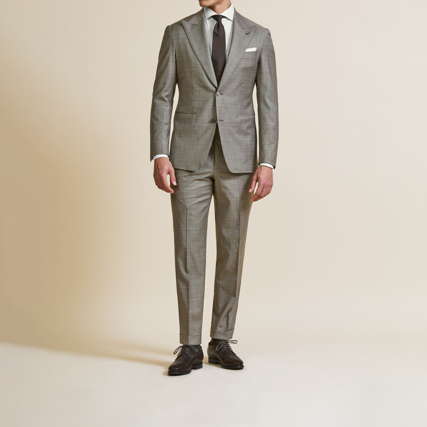A gray, buttoned up Pearce Bespoke Greater Syracuse suit on a male model.
