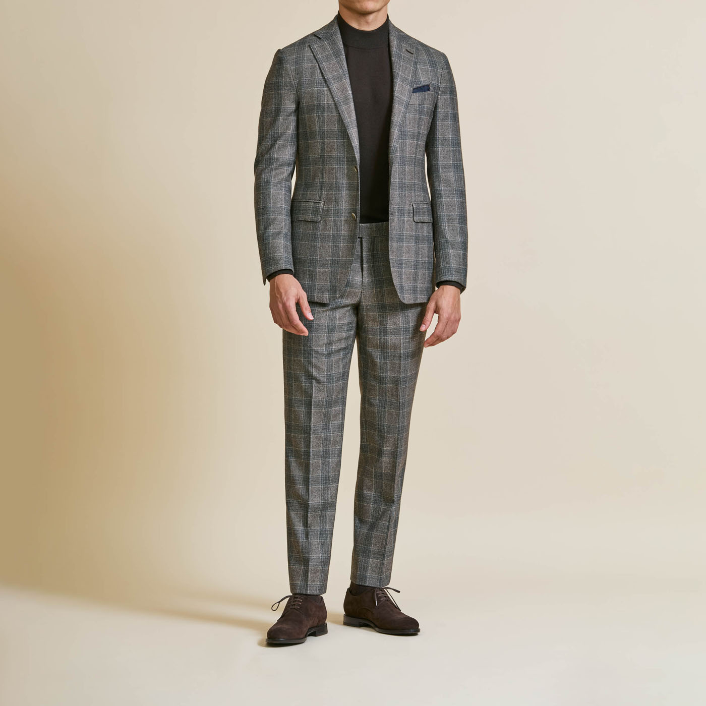 A male model wearing a dark gray custom suit from Pearce Bespoke Greater Syracuse.