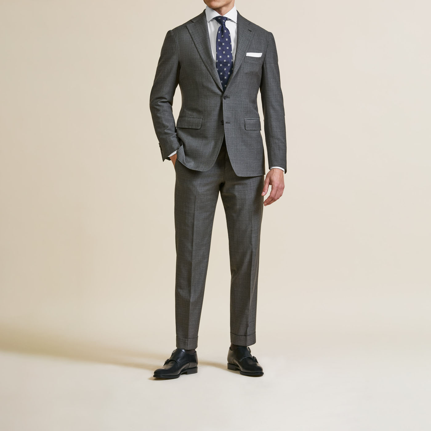 A male model wearing a Pearce Bespoke Greater Syracuse suit with a blue tie.