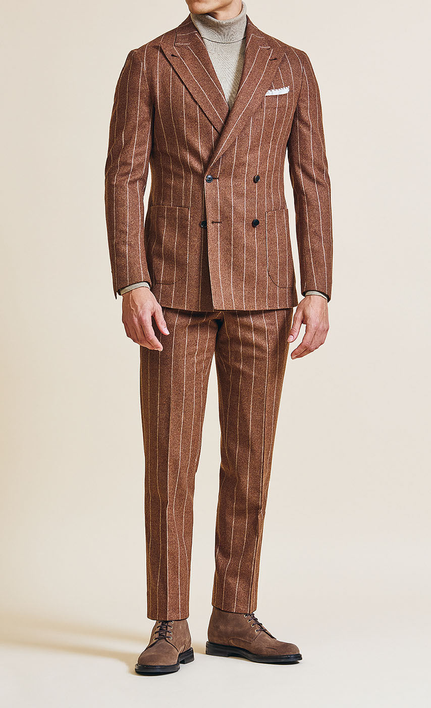 A male model styling a Pearce Bespoke Greater Syracuse custom suit in a bronze color with light pinstripes.