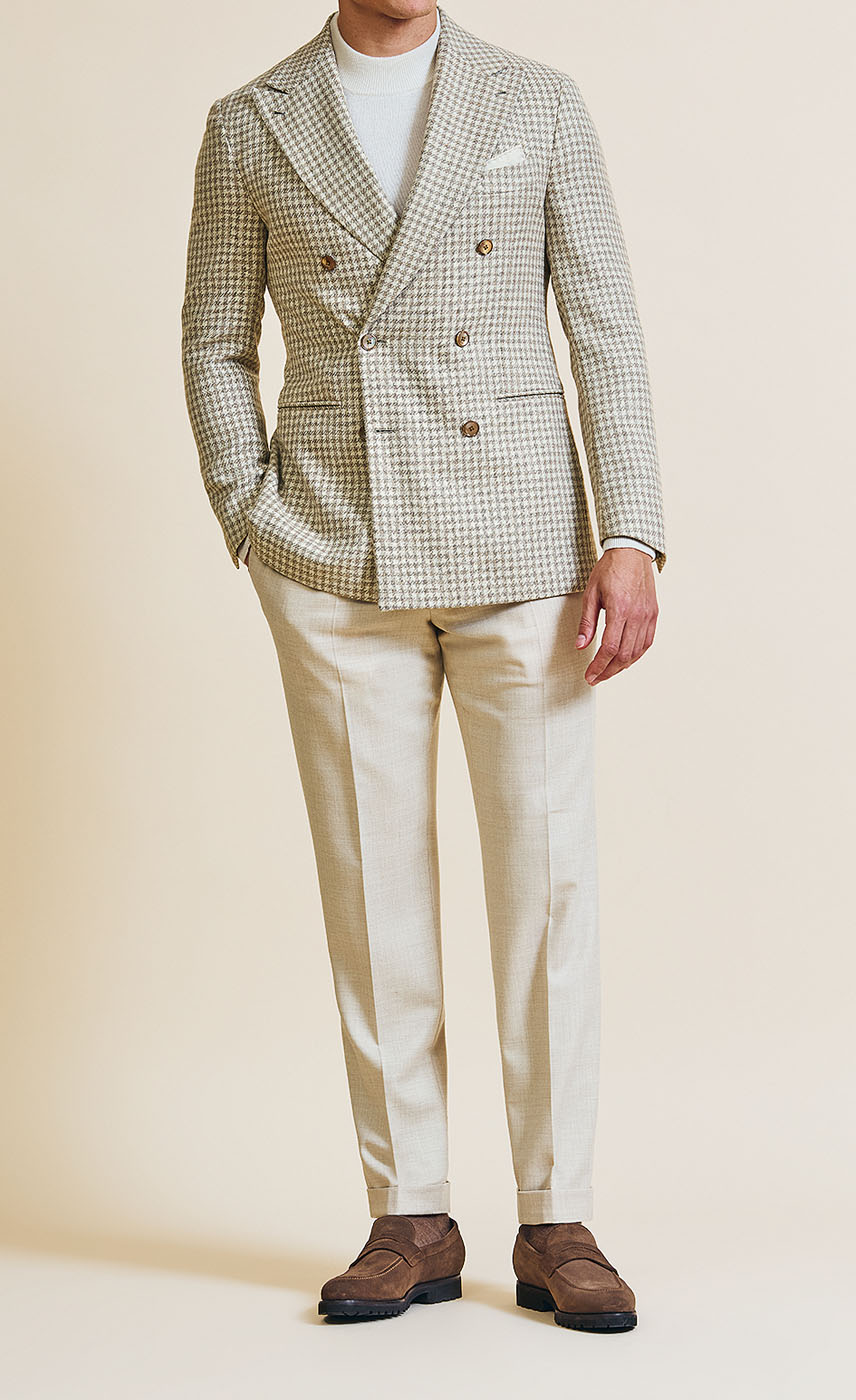 A cream-colored double-breasted Pearce Bespoke Greater Syracuse custom sportscoat on a male model.