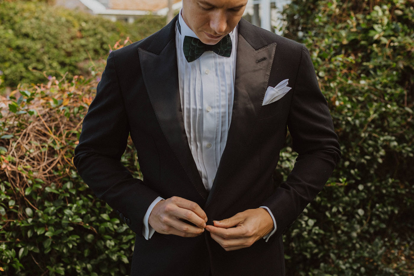 A groomsman wearing a classic black and white tuxedo from Pearce Bespoke.